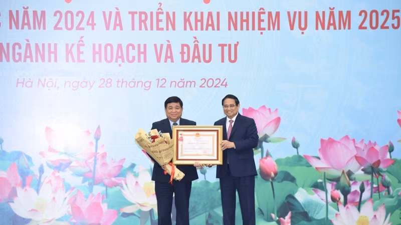 Thủ tướng Phạm Minh Chính trao Huân chương Lao động hạng Nhất tặng Bộ trưởng Kế hoạch và Đầu tư Nguyễn Chí Dũng. (Ảnh: TRẦN HẢI)