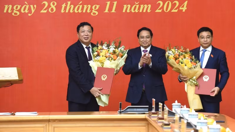 Thủ tướng Phạm Minh Chính tặng hoa chúc mừng Bộ trưởng Tài chính Nguyễn Văn Thắng và Bộ trưởng Giao thông vận tải Trần Hồng Minh. (Ảnh: Trần Hải)
