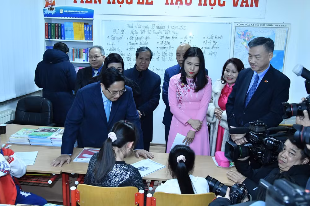 Thủ tướng Phạm Minh Chính hỏi thăm việc học tiếng Việt của các cháu học sinh của Trung tâm. (Ảnh: THANH GIANG)