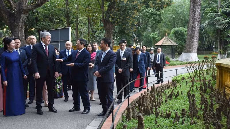 Thủ tướng Phạm Minh Chính giới thiệu với Thủ tướng Kyrgzystan Adylbek Kasymaliev về Nhà sàn Bác Hồ trong Khu Di tích Phủ Chủ tịch.