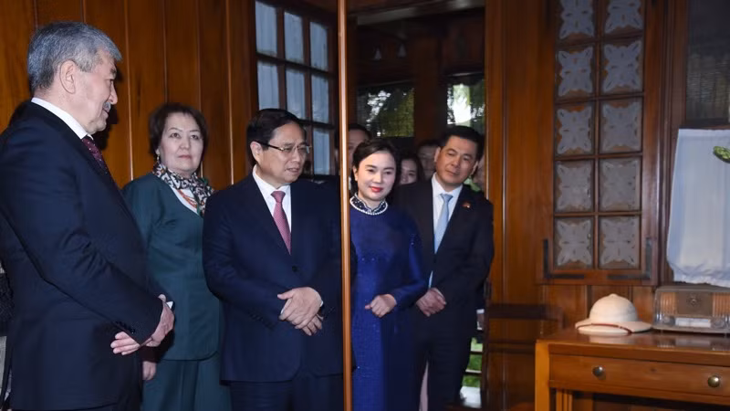 Thủ tướng Phạm Minh Chính giới thiệu với Thủ tướng Kyrgzystan Adylbek Kasymaliev về các hiện vật tại Nhà sàn Bác Hồ.