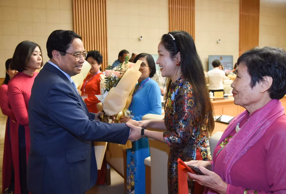 Thủ tướng Phạm Minh Chính tặng hoa chúc mừng các nữ đại biểu. (Ảnh: TRẦN HẢI)