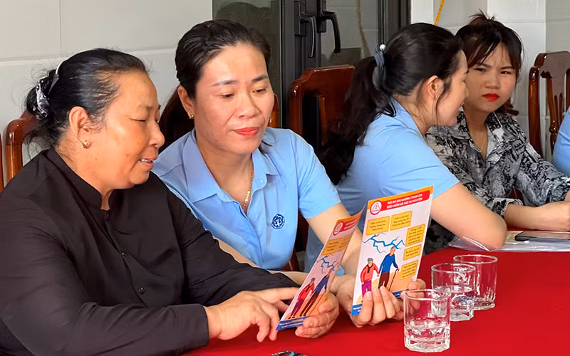 Cán bộ Bảo hiểm xã hội thị xã Ba Đồn (tỉnh Quảng Bình) tuyên truyền chính sách bảo hiểm xã hội tự nguyện cho người dân.