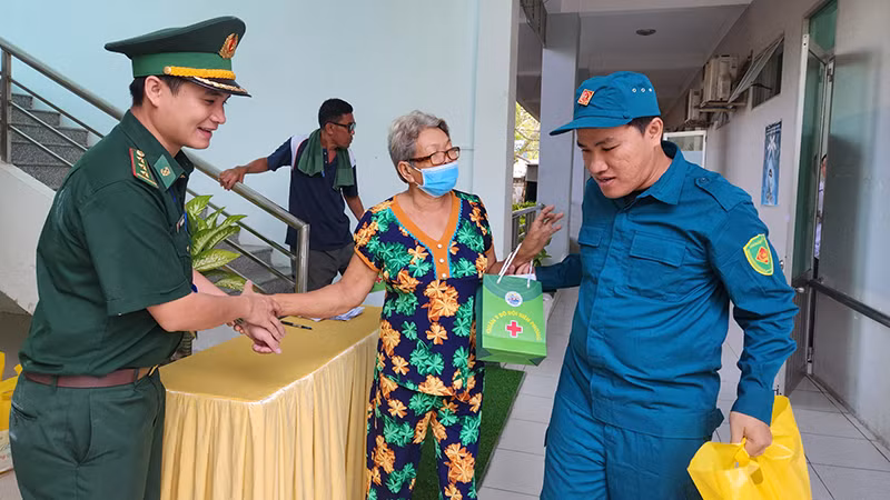 Bộ đội Biên phòng, dân quân hỗ trợ người dân đến khám bệnh, cấp phát thuốc miễn phí và nhận quà Tết tại thành phố Hà Tiên, tỉnh Kiên Giang. 