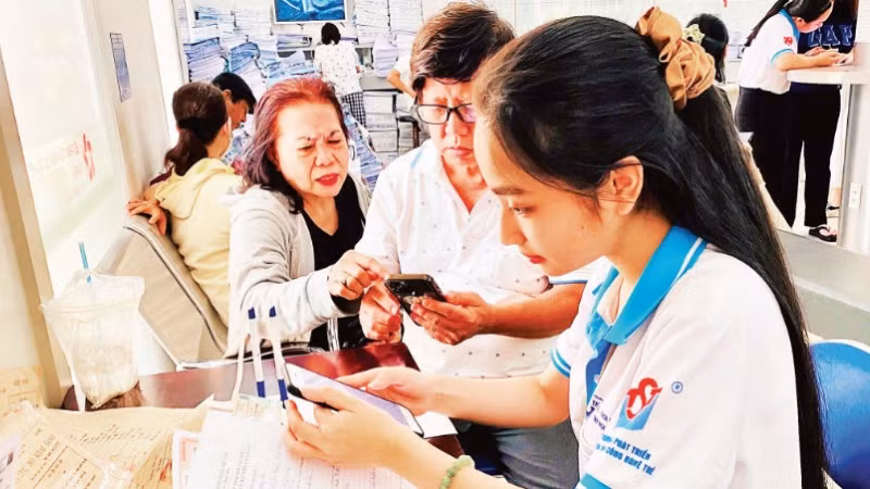 Tình nguyện viên Trung tâm Phát triển khoa học và công nghệ trẻ (Thành đoàn TP Hồ Chí Minh) hỗ trợ người dân làm các thủ tục hành chính.