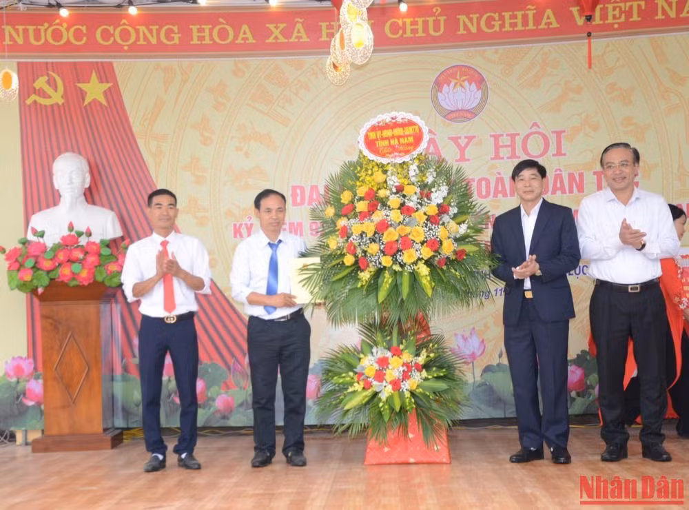 Các đồng chí lãnh đạo tỉnh tặng hoa và quà cho đại diện thôn An Thuận nhân Ngày hội Đại đoàn kết toàn dân tộc.