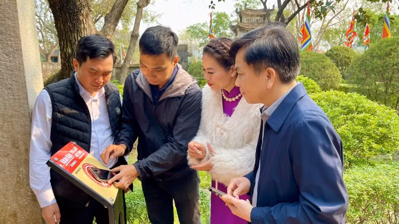 Người dân Ninh Bình thử nghiệm check-in bảng gắn chip NFC thuộc Dự án "Yêu lắm Việt Nam" của Báo Nhân Dân.