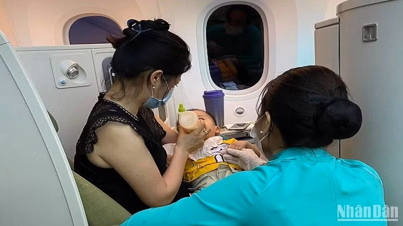 Tiếp viên Vietnam Airlines hỗ trợ chăm sóc sức khỏe hành khách trên một chuyến bay.