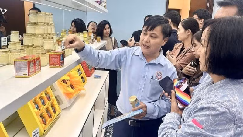Đại diện doanh nghiệp hướng dẫn cách nhận biết hàng thật với hàng giả cho khách tham quan. Ảnh: Hải Anh