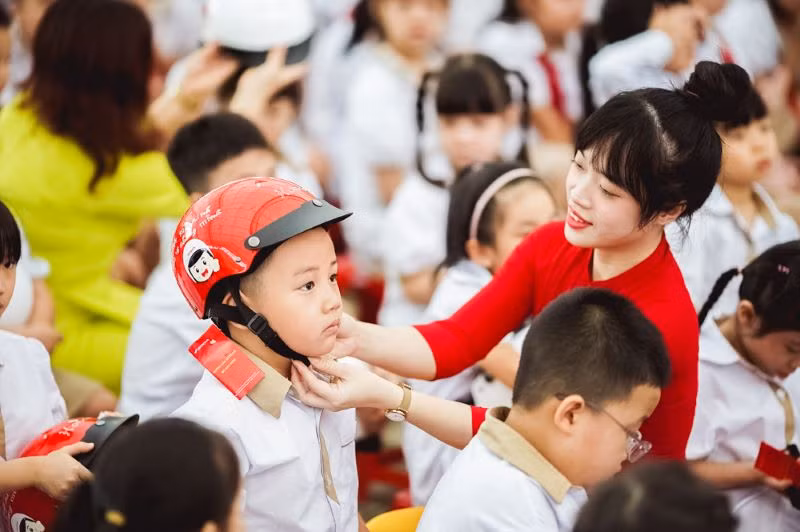 Với các em học sinh lớp 1 – lứa tuổi quan trọng hình thành nhận thức, tư duy, thì việc tạo cho các em thói quen luôn đội mũ đạt chuẩn khi ngồi sau xe máy là hết sức cần thiết.