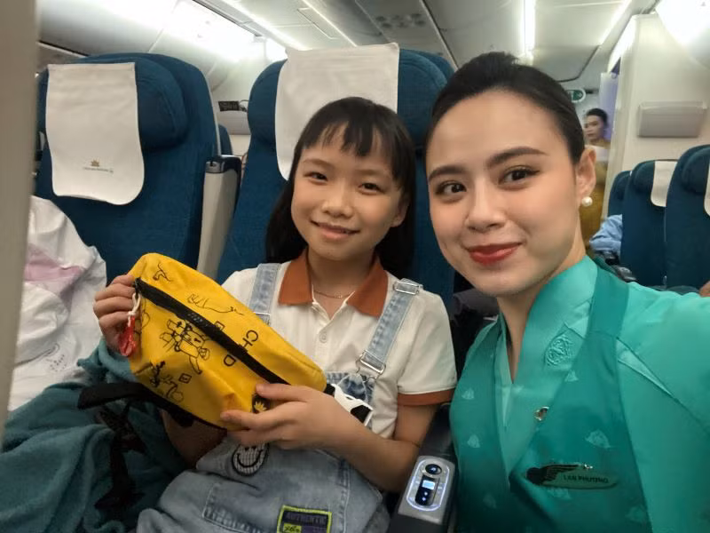 Hành khách thích thú trước sản phẩm túi từ áo phao cũ nhằm cổ động bảo vệ môi trường.