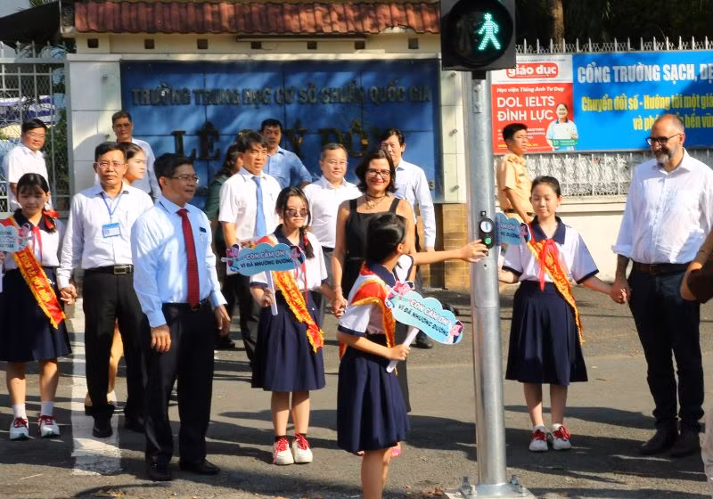 Học sinh THCS Lê Quý Đôn sử dụng đèn tín hiệu dành cho người đi bộ tại cổng trường.