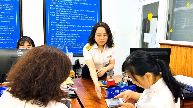 Cán bộ thuế hướng dẫn người dân kê khai, nộp thuế điện tử.