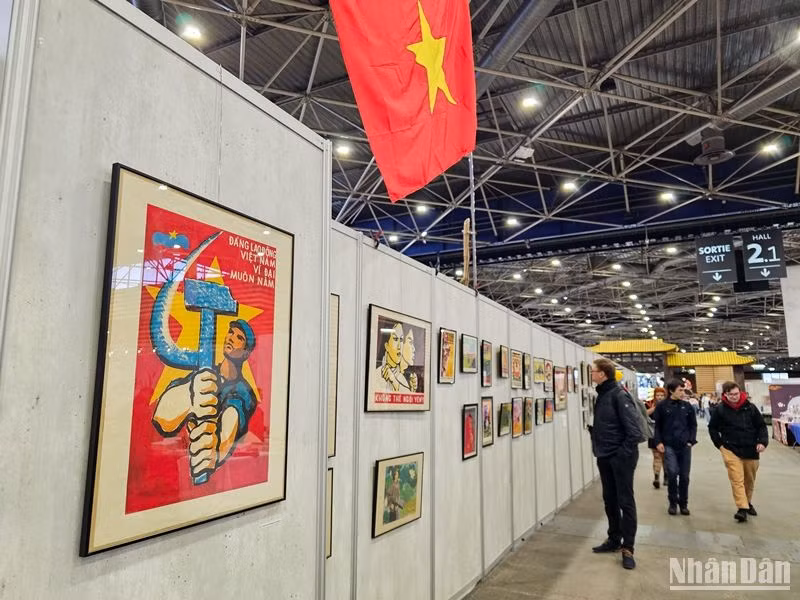 Những bức tranh vẽ cổ động phong trào thi đua yêu nước của Việt Nam thu hút sự chú ý của khách tham quan. (Ảnh: MINH DUY)