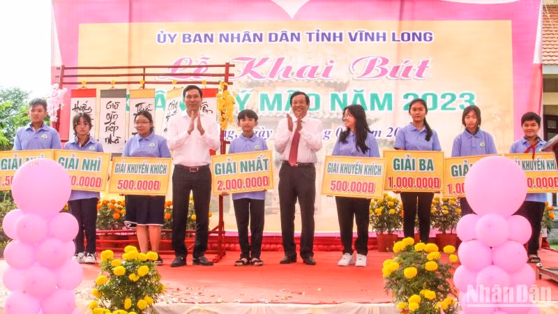 Khen thưởng các em học sinh đoạt giải trong cuộc thi viết chữ đẹp. (Ảnh: BÁ DŨNG)