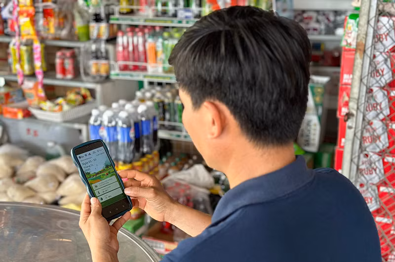 Một nông dân ở An Giang trải nghiệm Bản tin “Thời tiết nông vụ” phiên bản cải tiến năm 2024. (Ảnh CIAT)