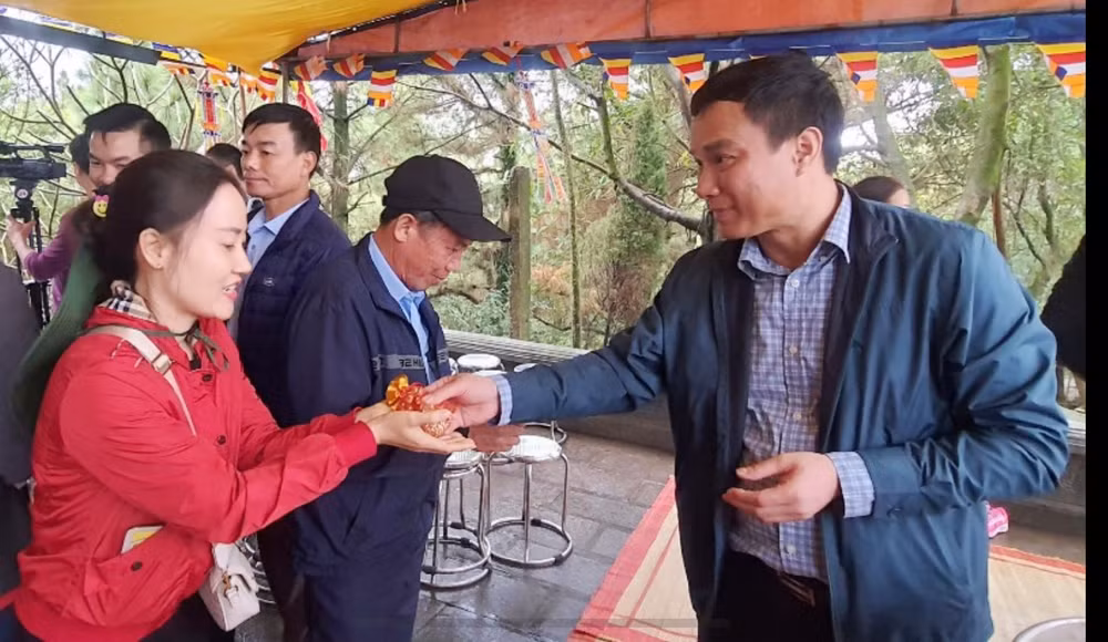 Chủ tịch UBND tỉnh Hải Dương Triệu Thế Hùng phát ngũ cốc cho nhân dân và du khách dự lễ tế.