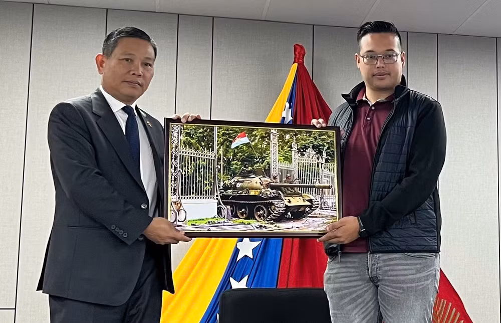 Đại sứ Vũ Trung Mỹ trao bức ảnh Chiếc xe tăng Xe tăng của Lữ đoàn 203, Sư đoàn 304, Quân đoàn 2 tiến vào Dinh Độc Lập, trưa 30/4/1975 tặng lãnh đạo Trường đào tạo cán bộ lãnh đạo thanh niên quốc tế “Antonio Jose de Sucre” (Ảnh: Đại sứ quán Việt Nam tại Venezuela) Đại sứ Vũ Trung Mỹ trao bức ảnh Chiếc xe tăng Xe tăng của Lữ đoàn 203, Sư đoàn 304, Quân đoàn 2 tiến vào Dinh Độc Lập, trưa 30/4/1975 tặng lãnh đạo Trường đào tạo cán bộ lãnh đạo thanh niên quốc tế “Antonio Jose de Sucre” (Ảnh: Đại sứ quán Việt Nam tại Venezuela)