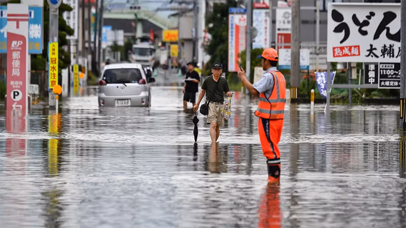 Người dân lội qua tuyến phố bị ngập tại thành phố Kurume, tỉnh Fukuoka, ngày 10/7/2023. (Ảnh: Kazuhiro Nogi/Getty Images) Người dân lội qua tuyến phố bị ngập tại thành phố Kurume, tỉnh Fukuoka, ngày 10/7/2023. (Ảnh: Kazuhiro Nogi/Getty Images)