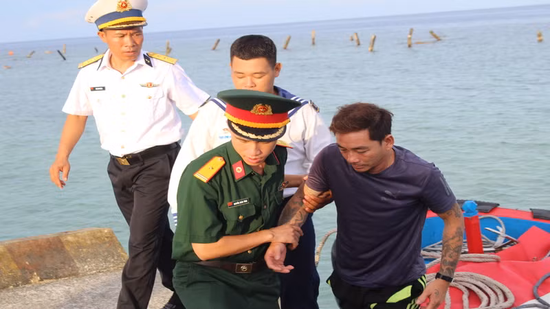 Đưa bệnh nhân Trần Văn Ưu từ tàu cá lên Bệnh xá đảo Song Tử Tây. ( Ảnh: CTV) 