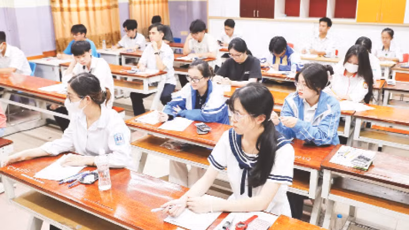 Thí sinh làm thủ tục dự thi tại điểm thi Trường THPT Nguyễn Bỉnh Khiêm, quận Cầu Giấy. (Ảnh Viết Chung)