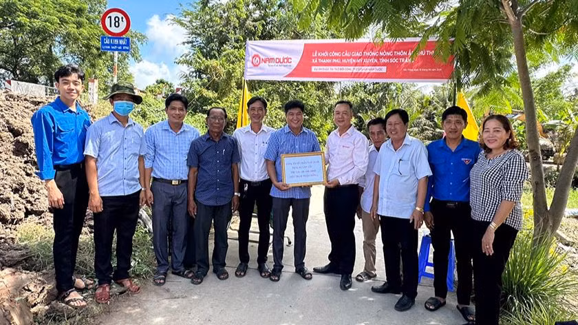 Đại diện lãnh đạo Công ty Nam Dược trao kinh phí hỗ trợ xây cầu cho địa phương.