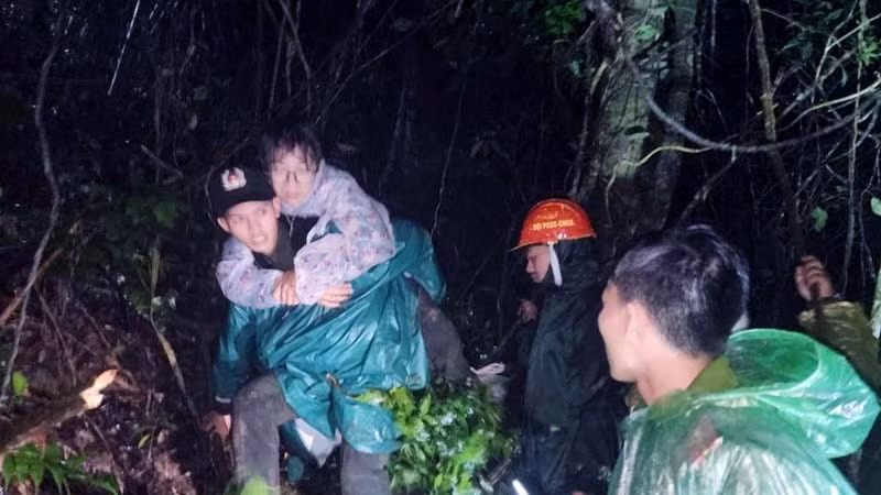 Lực lượng cứu hộ đưa các du khách bị lạc giữa rừng xuống núi sau khi tìm thấy.