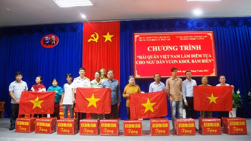 Tặng áo phao, cờ Tổ quốc và quà cho các gia đình ngư dân có hoàn cảnh khó khăn.