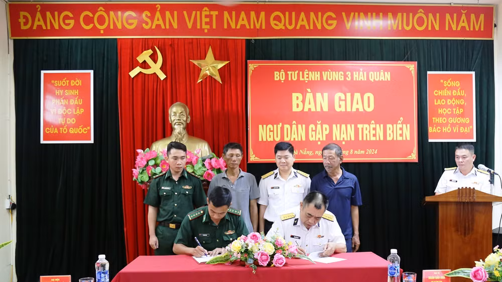 Đại diện Bộ Tư lệnh Vùng 3 Hải quân và Đồn Biên phòng Sơn Trà ký giao, nhận hai ngư dân gặp nạn.