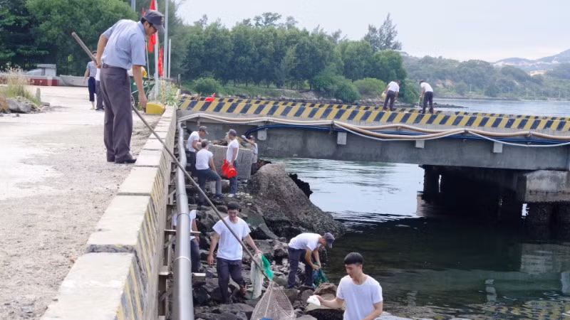 Vớt rác thải tại khu vực cầu cảng của đơn vị.