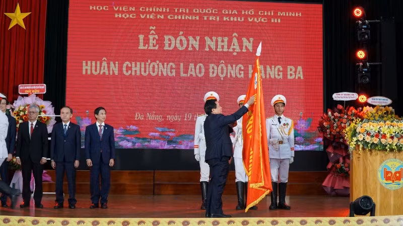 Đồng chí Nguyễn Xuân Thắng gắn Huân chương Lao động Hạng 3 lên lá cờ truyền thống của Học viện Chính trị khu vực III.
