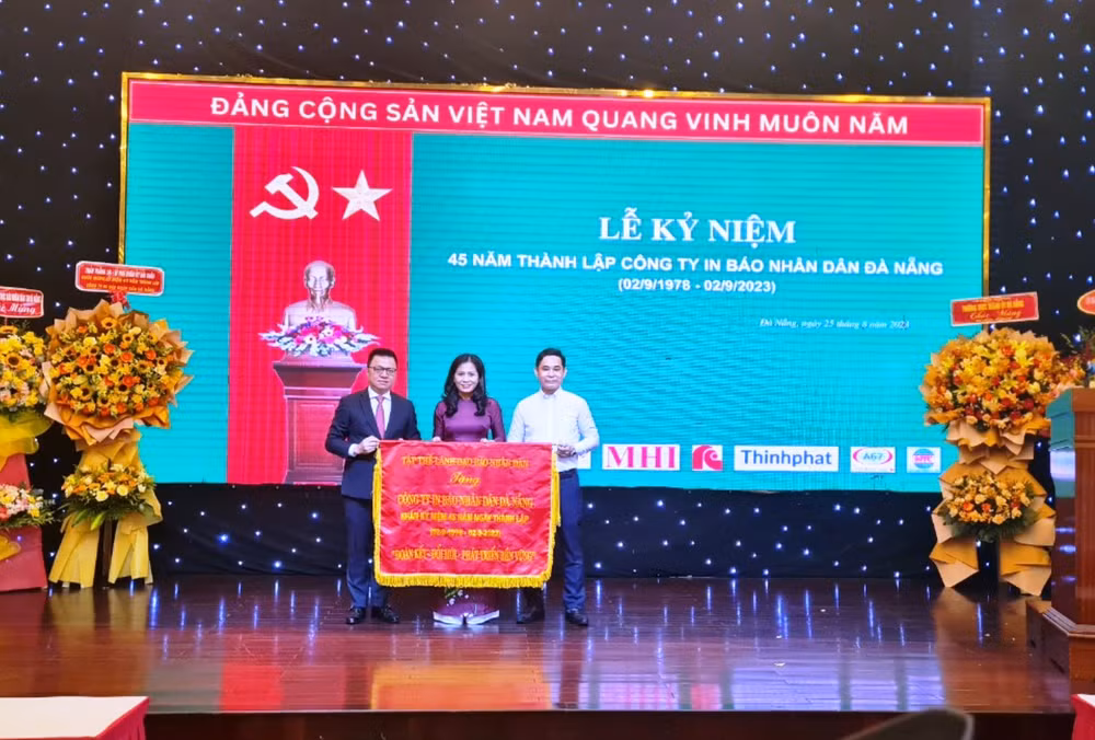 Tổng Biên tập Báo Nhân Dân Lê Quốc Minh trao bức trướng với dòng chữ “Đoàn kết- Đổi mới-Phát triển bền vững” tặng tập thể lãnh đạo, nhân viên Công ty In Báo Nhân Dân Đà Nẵng.
