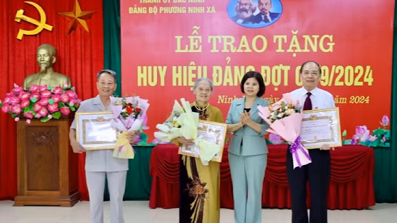 Đồng chí Nguyễn Hương Giang, Phó Bí thư Thường trực Tỉnh ủy, Chủ tịch Hội đồng nhân dân tỉnh chúc mừng các đảng viên được trao tặng Huy hiệu Đảng tại Đảng bộ phường Ninh Xá, thành phố Bắc Ninh.