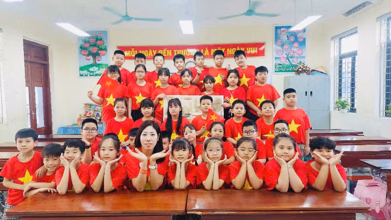Cô và trò trường Tiểu học Ninh Xá, thành phố Bắc Ninh check-in cùng phụ san đặc biệt của Báo Nhân Dân.