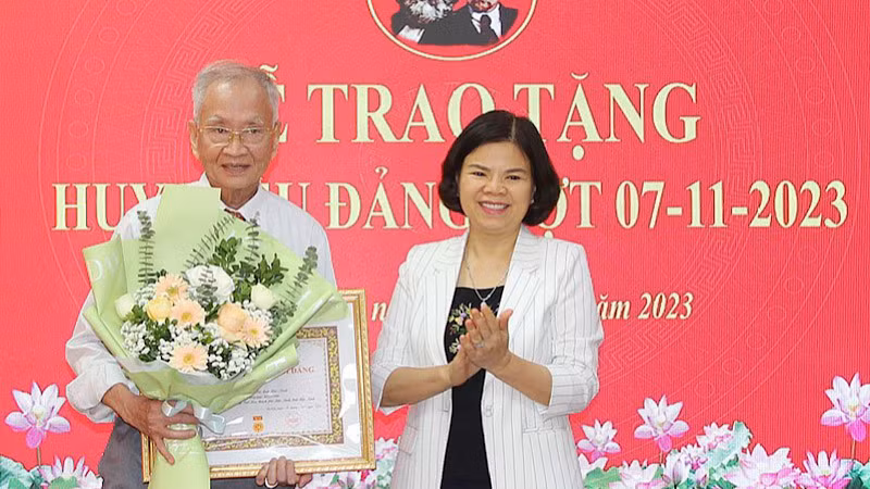 Chủ tịch Ủy ban nhân dân tỉnh Bắc Ninh Nguyễn Hương Giang trao Huy hiệu 60 năm tuổi Đảng tặng đảng viên Vũ Đức Trung, ở phường Suối Hoa, thành phố Bắc Ninh.