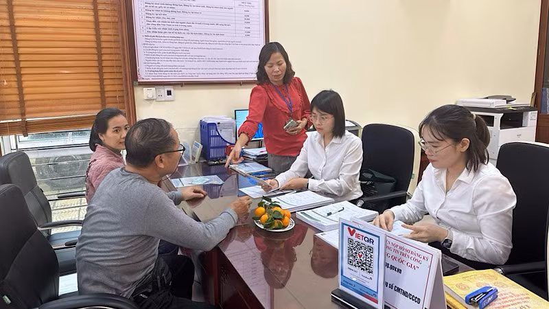 Cán bộ ngân hàng hướng dẫn người dân mở tài khoản để thực hiện chi trả an sinh xã hội không dùng tiền mặt. 