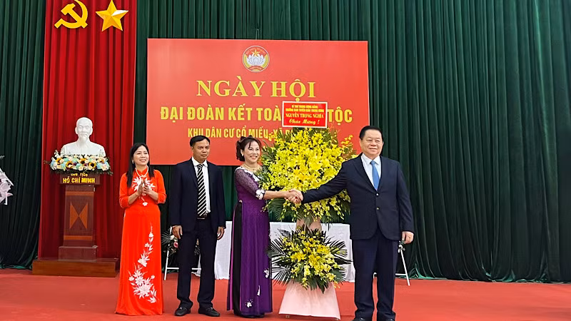 Đồng chí Nguyễn Trọng Nghĩa tặng hoa, chúc mừng Ngày hội Đại đoàn kết toàn dân tộc tại thôn Cổ Miếu.