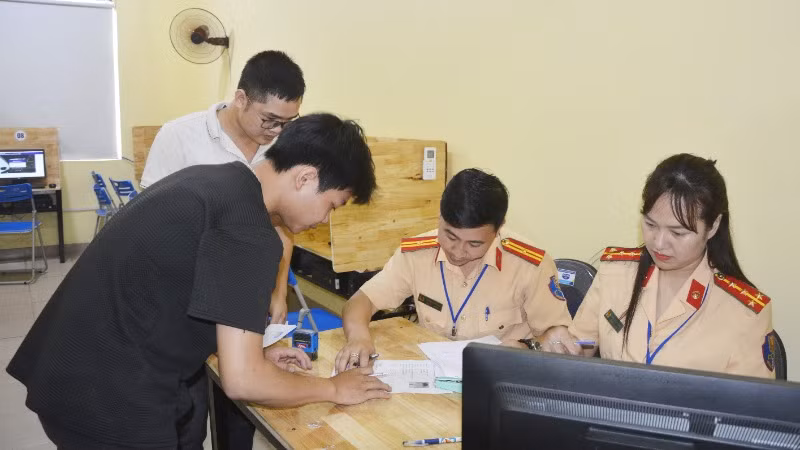 Cán bộ Phòng Cảnh sát Giao thông hướng dẫn học viên thủ tục thi.