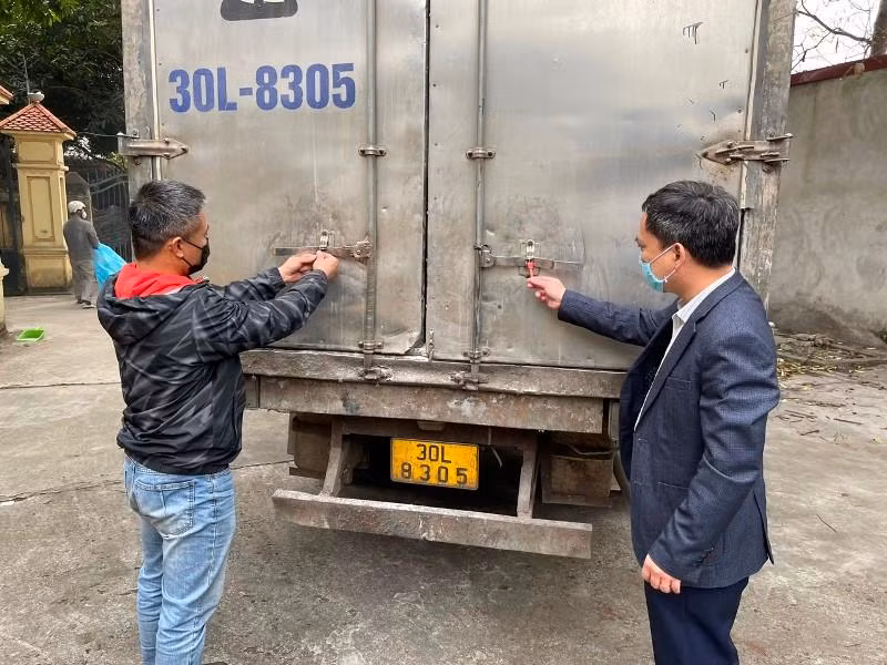 Ông Nghiêm Quang Tuấn, Trưởng Phòng Thanh tra pháp chế Cục Bảo vệ thực vật (bên phải) kiểm tra niêm phong xe trước khi bàn giao cho đơn vị vận chuyển thuốc bảo vệ thực vật ngoài danh mục đến nơi tiêu hủy.