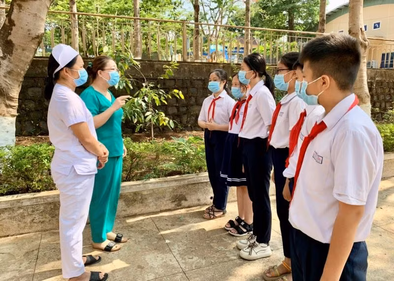 Nhân viên y tế phường Hoa Lư (TP. Pleiku, Gia Lai) tuyên truyền về phòng, chống dịch Covid-19 cho các em học sinh. (Ảnh: Như Nguyện) 