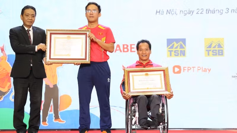 Vận động viên Lê Văn Công (bìa phải) và huấn luyện viên Lê Quang Thái nhận Huân chương Lao động hạng Ba.