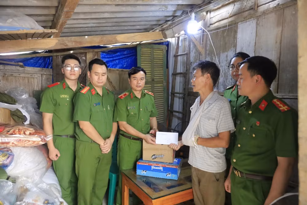 Thiếu tướng Nguyễn Đắc Hoan trao hỗ trợ cho người dân bị thương do thiên tai. (Ảnh: THANH SƠN)