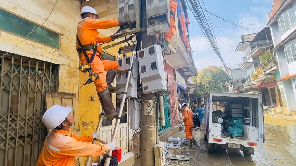 Công nhân điện lực thành phố Yên Bái lắp đặt công tơ trên trục đường Thanh Niên sau bão lũ. (Ảnh: THANH SƠN) Công nhân điện lực thành phố Yên Bái lắp đặt công tơ trên trục đường Thanh Niên sau bão lũ. (Ảnh: THANH SƠN)