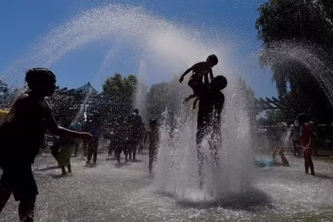 Người dân tránh nóng bên đài phun nước ở California, Mỹ. (Ảnh: THX/TTXVN)