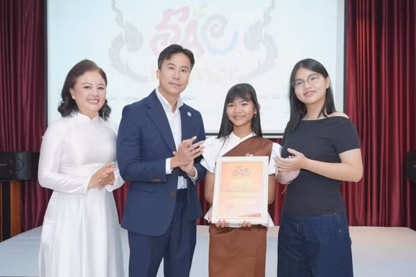 Bà Trương Ngọc Minh Đăng, nhà sáng lập Doanh nghiệp xã hội "Cùng con đi khắp thế gian", đồng sáng lập dự án "SẮC - 54 Dân tộc Việt Nam" trao chứng nhận đại sứ cho em Liêu Thị Ánh Nhi. (Ảnh: Ban tổ chức cung cấp)