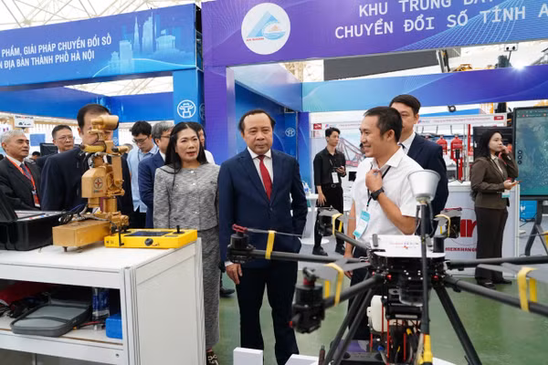 Các đại biểu tham quan gian hàng trưng bày sản phẩm chuyển đổi số tại sự kiện chào mừng Ngày Chuyển đổi số quốc gia năm 2026 do Bộ Khoa học và Công nghệ tổ chức. (Ảnh: Hà Linh)