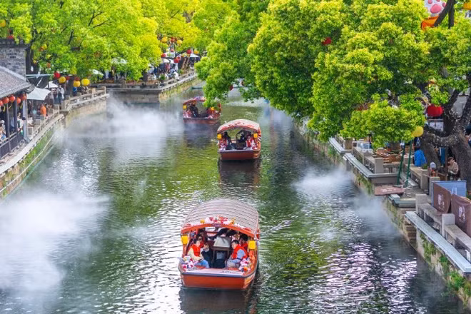 Du khách dạo chơi tại một điểm du lịch ở thành phố Vô Tích, tỉnh Giang Tô, Trung Quốc. (Ảnh: Tân Hoa xã)