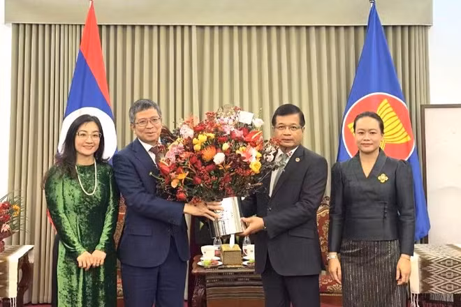 Đại sứ Phạm Thanh Bình tặng hoa chúc mừng Đại sứ quán Lào. (Ảnh: Đại sứ quán Việt Nam tại Trung Quốc)