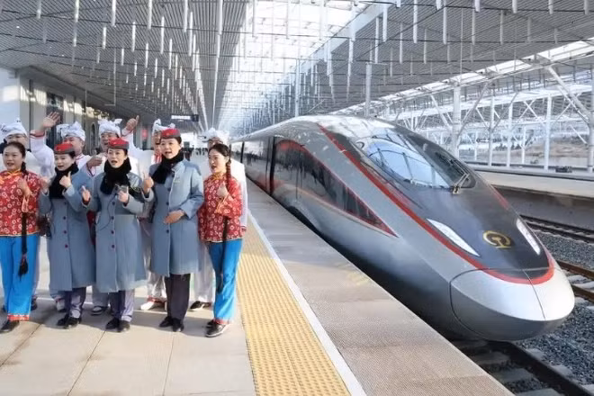 Nhân viên đường sắt và diễn viên chụp ảnh lưu niệm tại ga Diên An ngày 26/12. (Ảnh: China Daily)