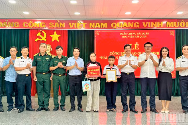 Đại tá Hồ Thanh Hòa, Phó Giám đốc Học viện Hải quân trao quyết định “Hải quân nhận đỡ đầu con ngư dân” cho hai cháu có hoàn cảnh khó khăn.